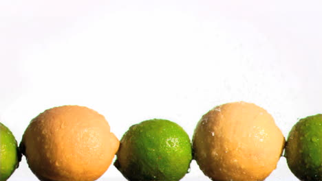 limones y limas en cámara súper lenta estando mojados