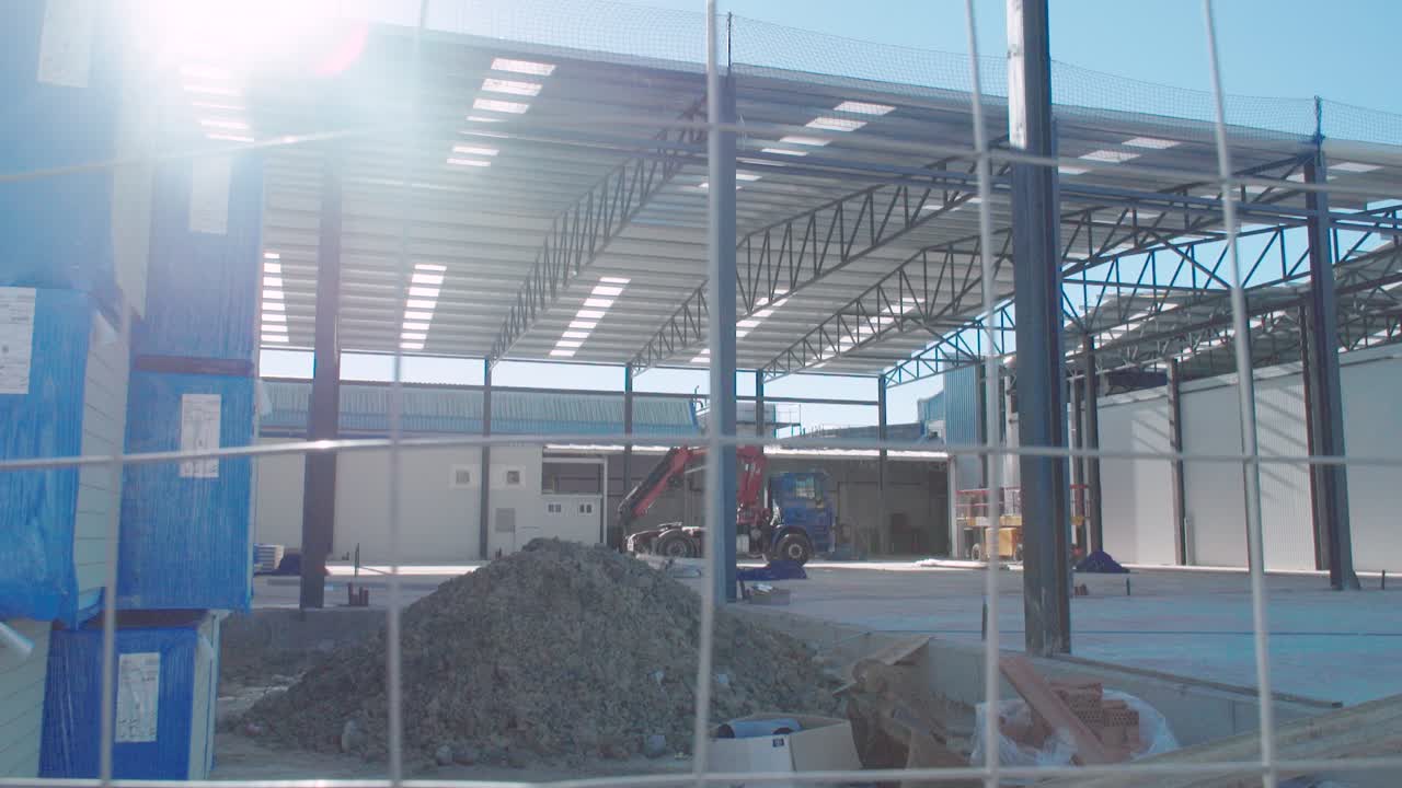 Slider shot of construction site with heavy machinery and bright sun flare