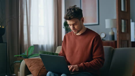 serious online manager working at laptop home close up. smart freelancer typing
