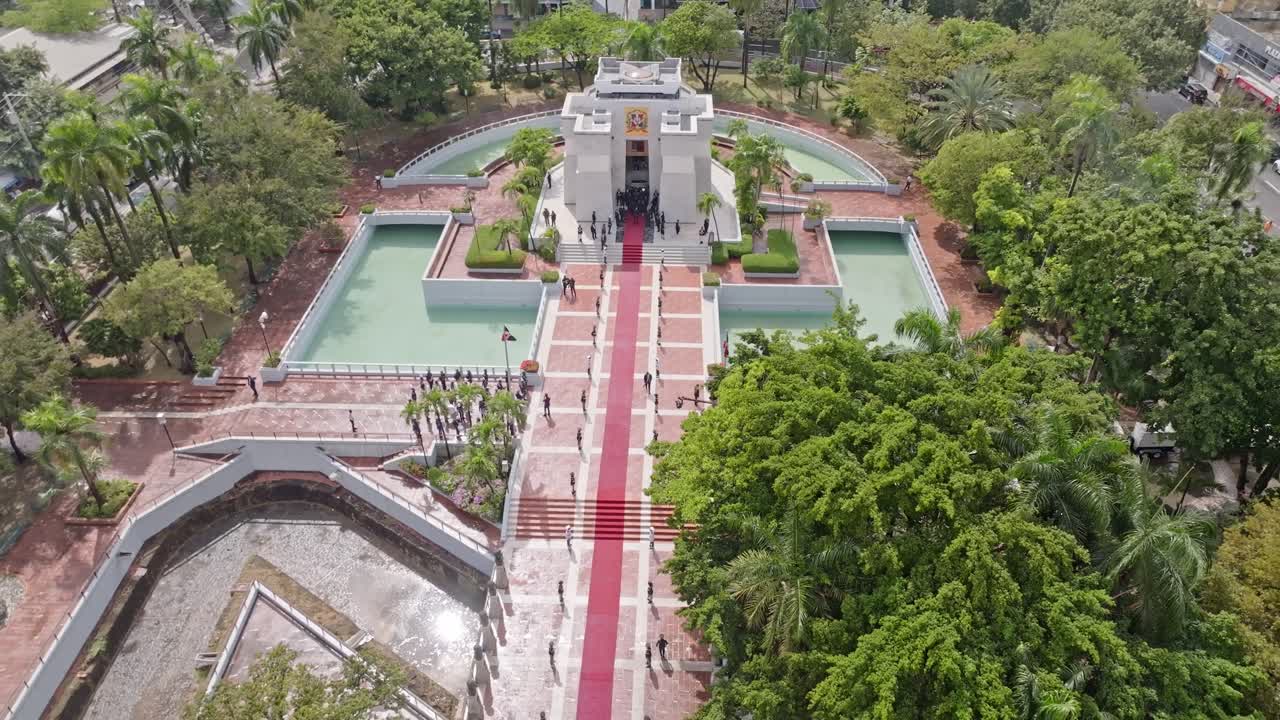 Aerial view of a mausoleum with a red carpet and people