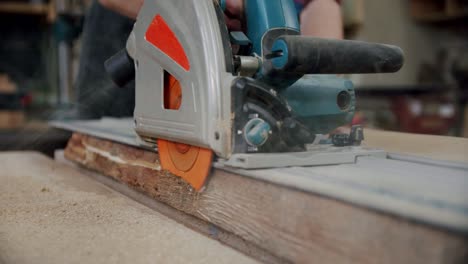 slow motion. the master cuts a wooden board with a circular saw in the woodworking workshop of a small furniture manufacturer. v3