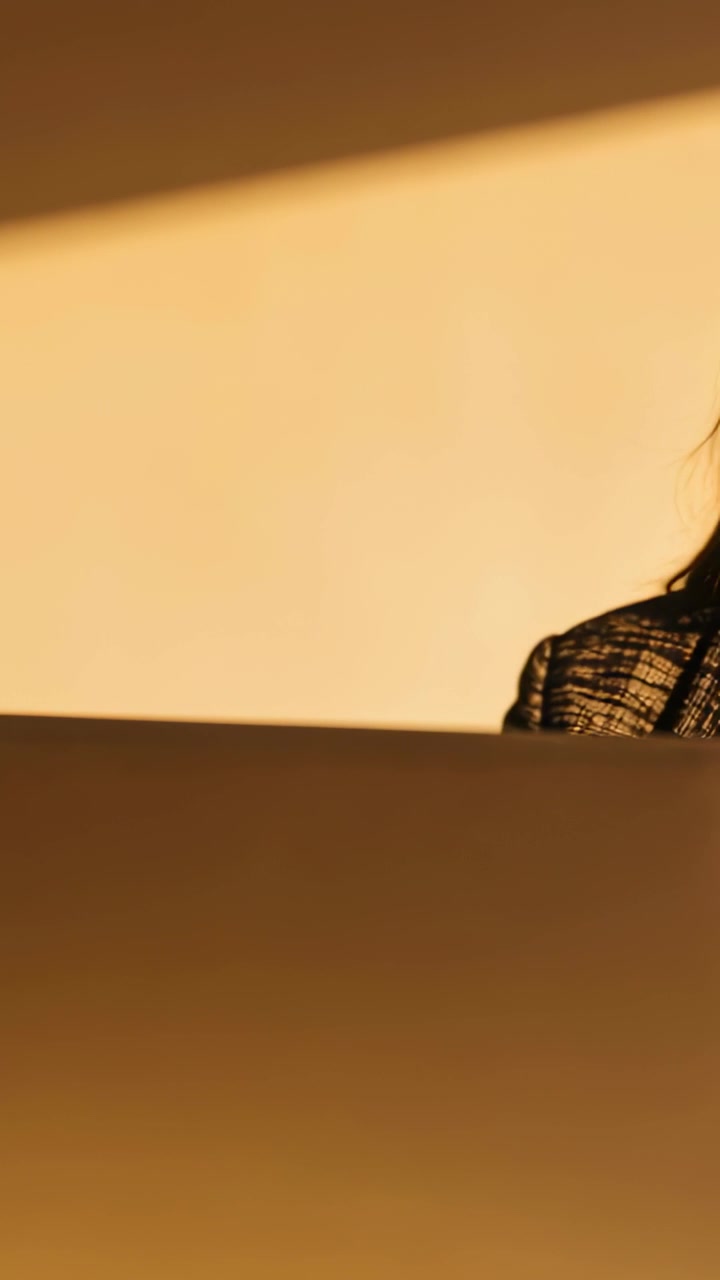 Vertical video: Entering woman in blazer settling behind laptop at desk starting work, copy space