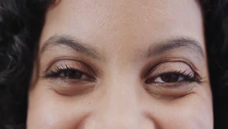 close-up portret van een gelukkige vrouw van twee rassen die in slow motion naar de camera kijkt.