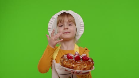 Child-girl-kid-dressed-as-professional-cook-chef-baker-eating-tasty-strawberry-pie-on-chroma-key