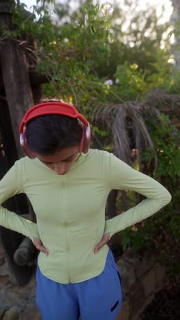 mujer haciendo ejercicio al aire libre con auriculares