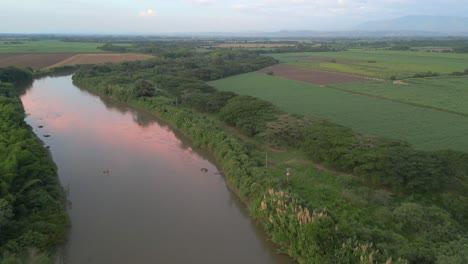 Luftaufnahme-Des-Flusses-Cauca-Bei-Sonnenuntergang-Mit-Wasserspiegelung