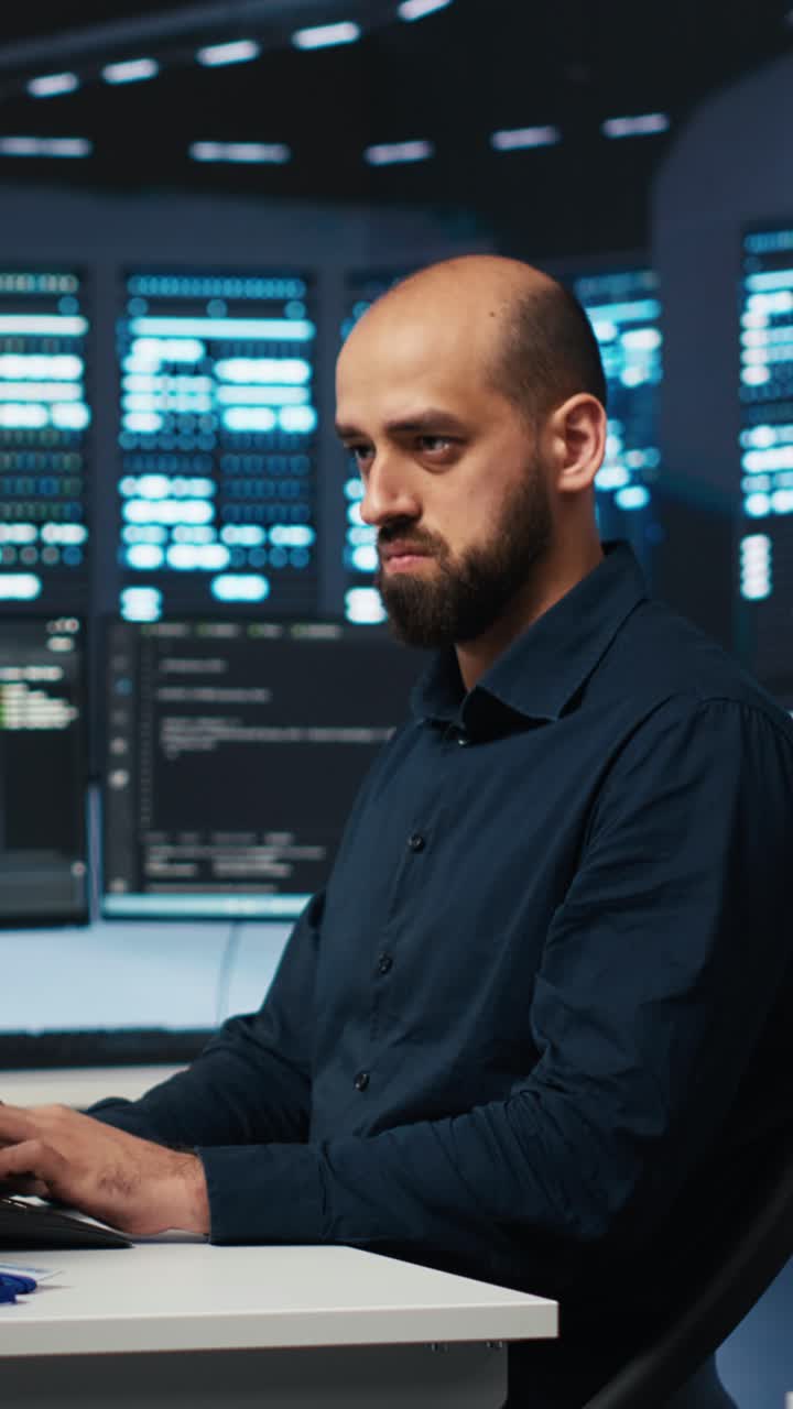 Fokusert programmerer som skriver kode i et mørkt serverrom