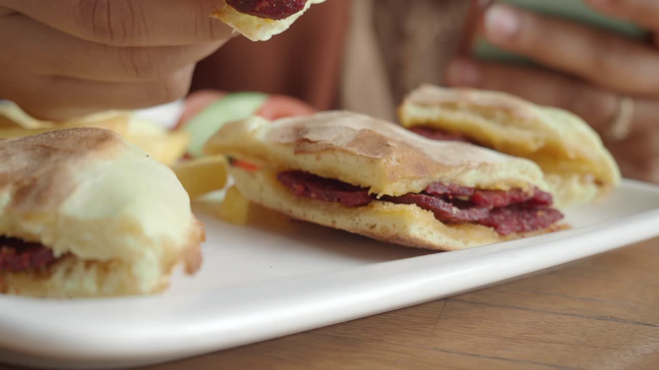persona comiendo un sándwich delicioso