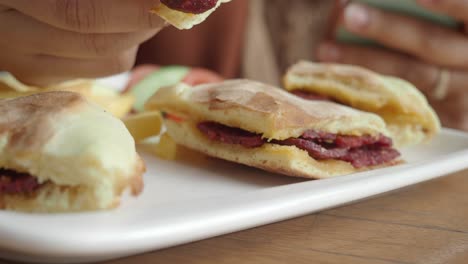 persona comiendo un sándwich delicioso