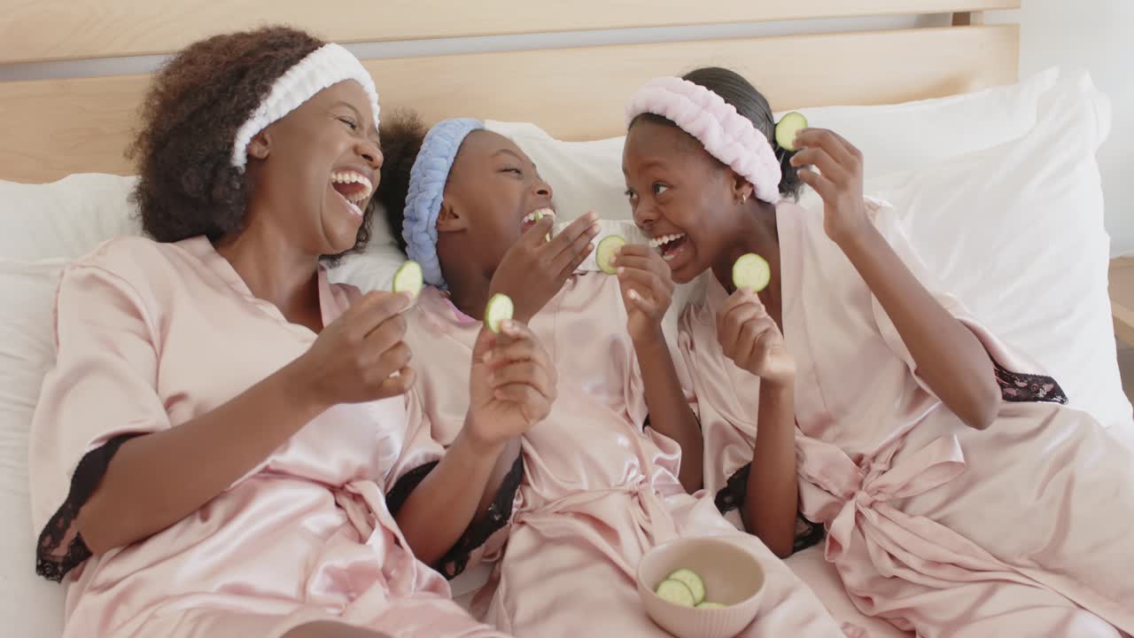 Mother placing cucumber, girls mimicking on bed, forming skincare moment with animated icons