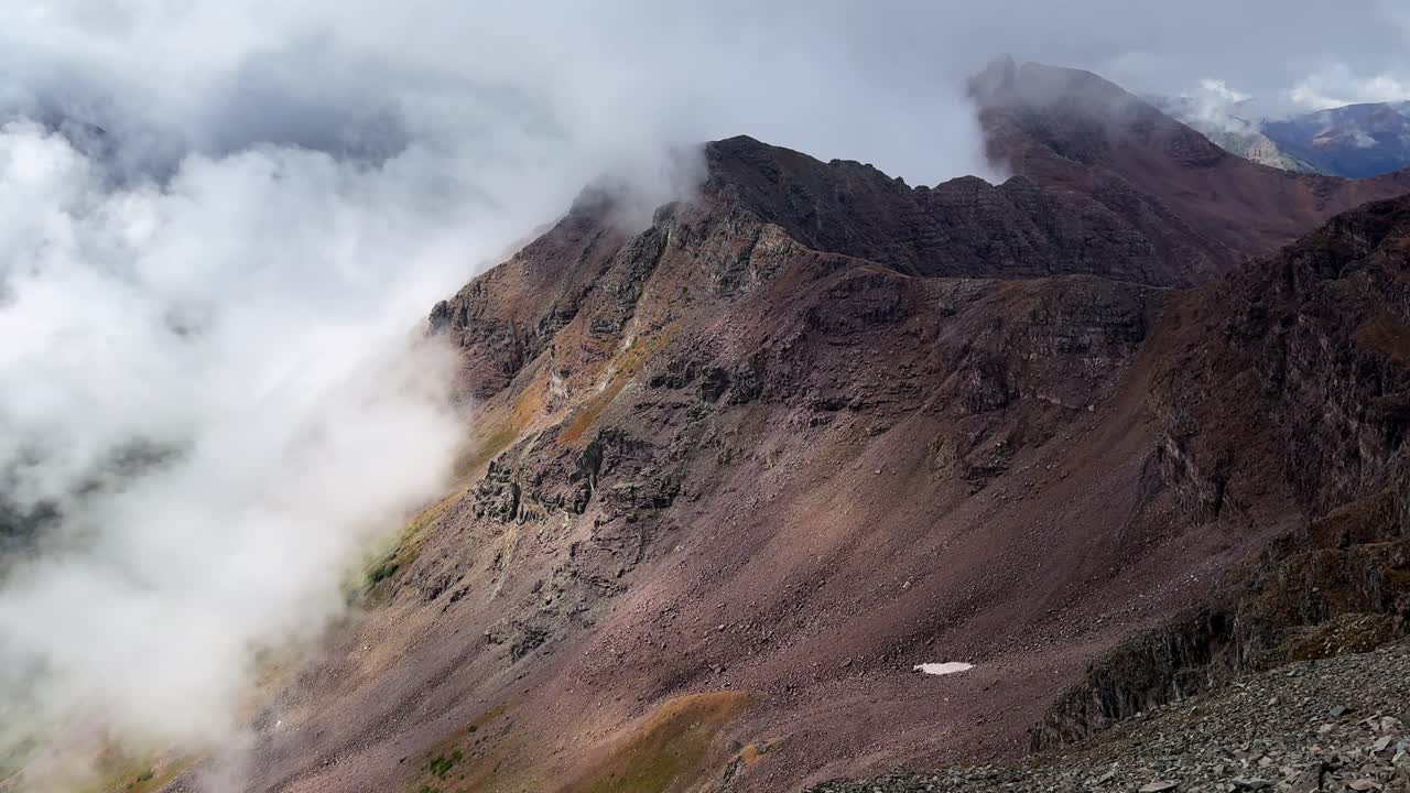 Maroon Peak rugged high alpine terrain Rocky Mountains Colorado Aspen Snowmass Maroon Bells Wilderness summer stormy foggy rainy snow clouds morning hike nature panoramic landscape view static shot