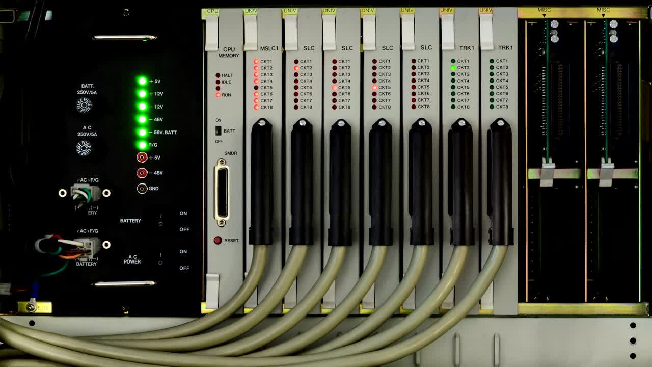 박이는 불빛으로 작업하는 앞 문이 없는 구식 전화 스위치 시스템