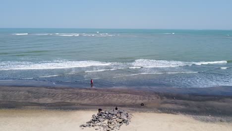 aerial view of interracial tourist couple walking on the beach in cape point, bakau - the gambia