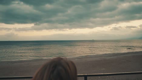 woman sitting on a bench and staring the beach sea view