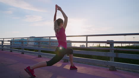 mujer estirándose en un puente al amanecer o al atardecer