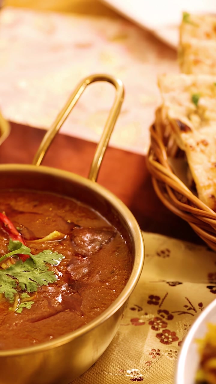 Inquadratura ravvicinata panoramica di pollo tandoori, riso biryani, raita e naan su un tavolo