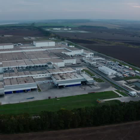 huge industrial plant on beautiful landscape. panoramic view of a manufacturing surrounded by nature in the morning. view from above.