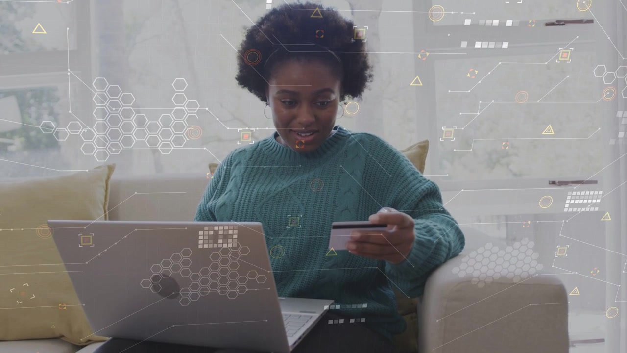 Adult woman typing on laptop holding card on sofa, showing finance HUD confirming order