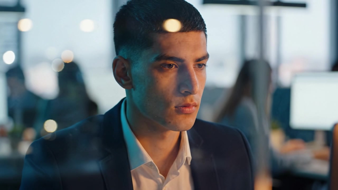 Focused Professional Gazes Intently at Computer Screen in Modern Office Environment, Capturing Deep Concentration and Work Engagement in Multiple Frames.