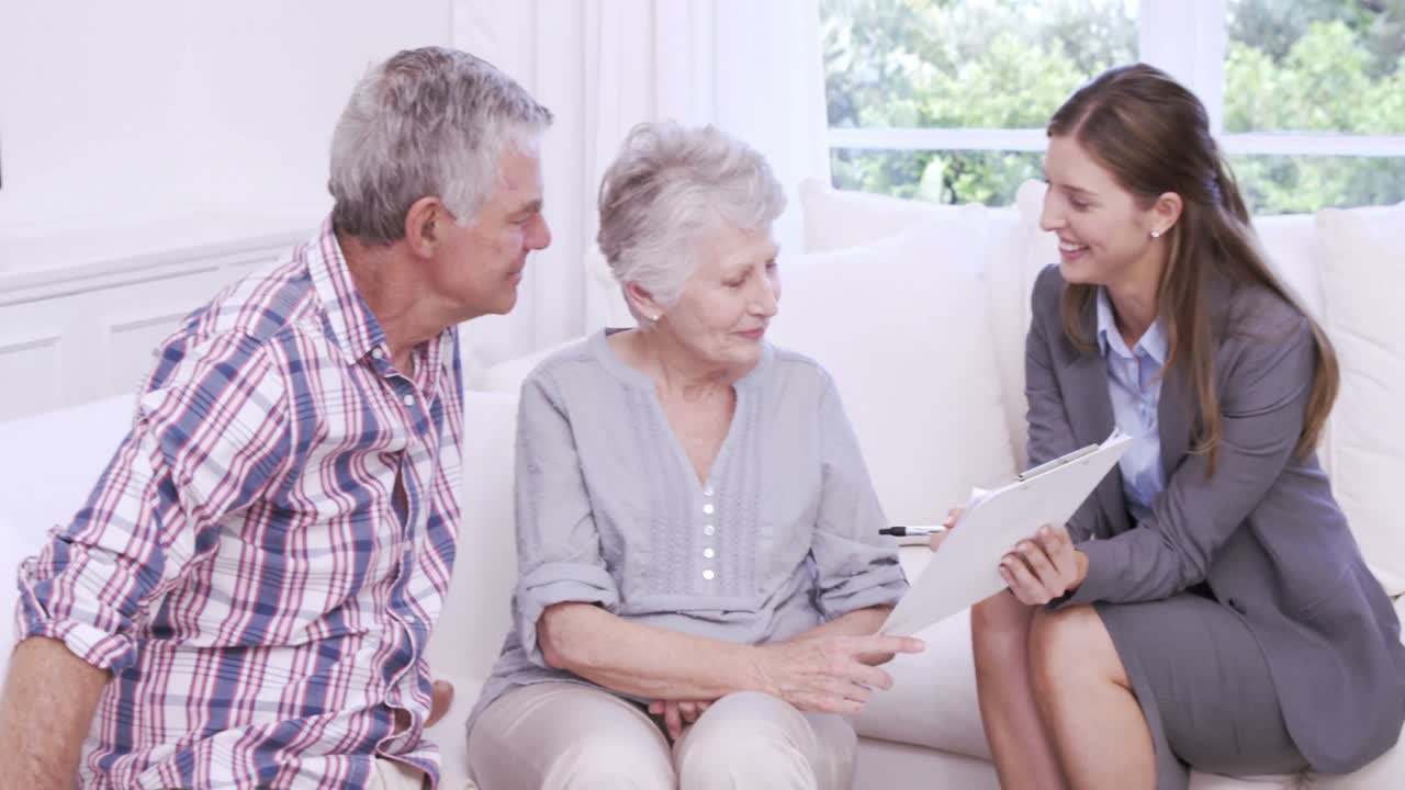 mujer de negocios mostrando un contrato a una pareja mayor