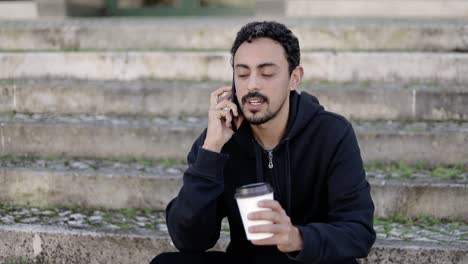 content man with coffee to go talking by smartphone