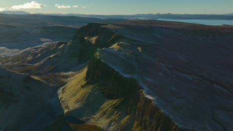 ancient landslip ridges of bioda buidhe in early morning winter sunshine with reveal of wider mountainous and moorland landscape beyond