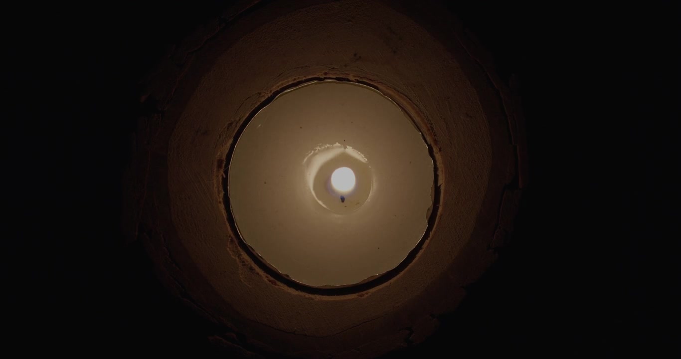 Pessoa acendendo uma vela com um fósforo