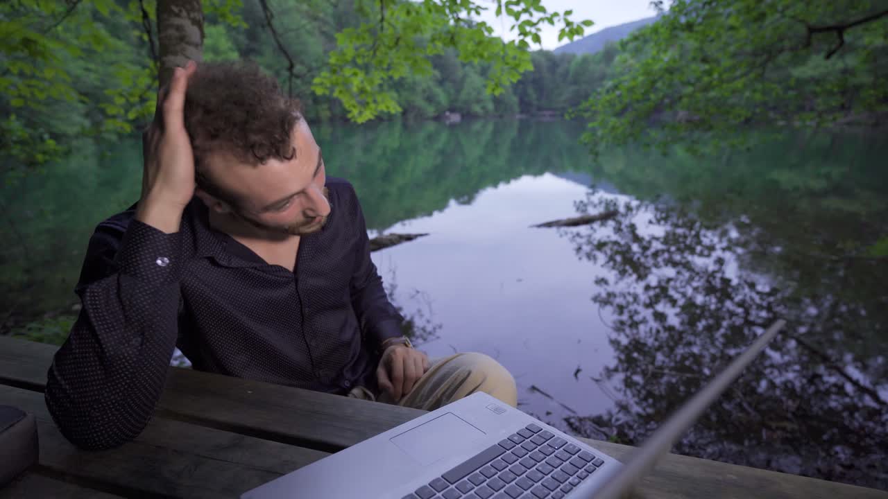 Businessman happily working in the forest.