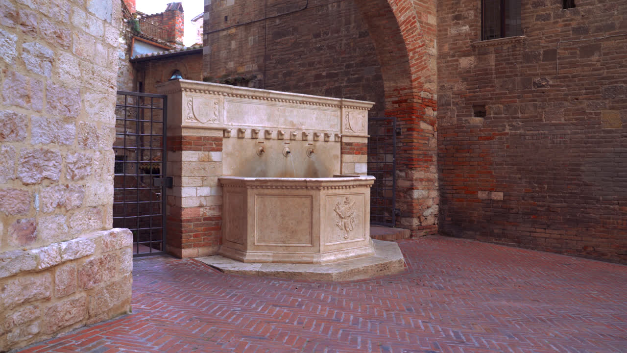 Stone courtyard with carved fountain and medieval architecture in Perugia