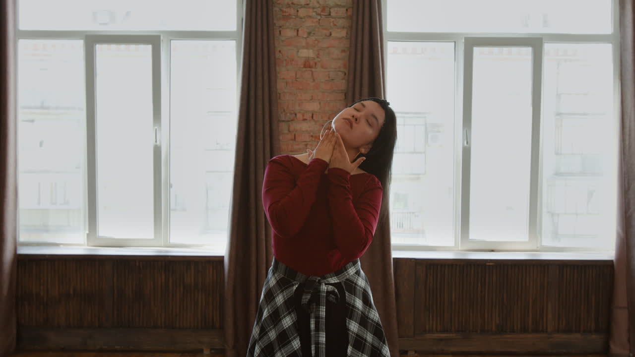 A woman performing movements in a studio setting