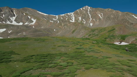 aerial cinematic drone early morning sunrise hiking trail grays and torreys 14er peaks rocky mountains colorado stunning landscape view mid summer green beautiful snow on top circling left movement