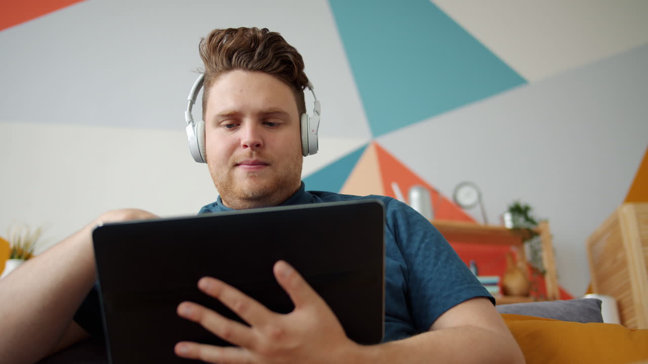 Man using tablet with headphones