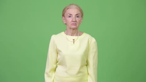 Studio shot of beautiful senior businesswoman with blond hair