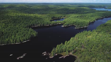 Crane-drone-view-of-a-remote-lake-surrounded-by-woods-and-trees-hb02
