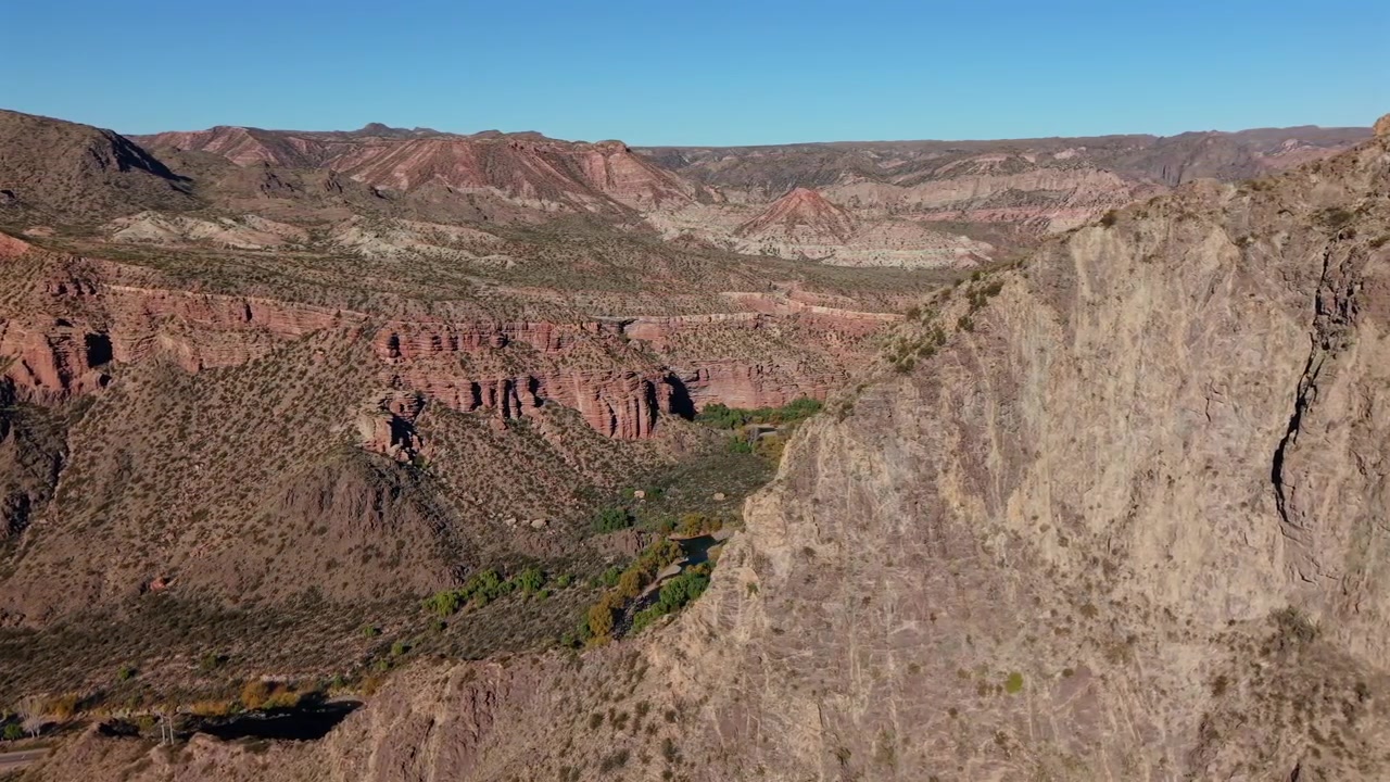 La vista aerea rivela aspre scogliere di canyon e un fiume serpeggiante nel paesaggio arido di Mendoza