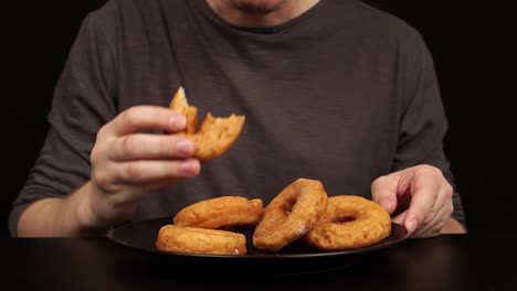 man eating a lot of doughnuts