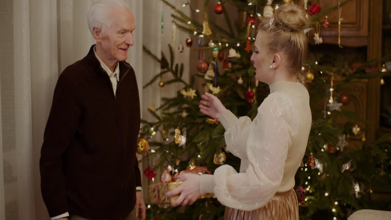 집에서 할아버지에게 크리스마스 선물을 주는 여자 2