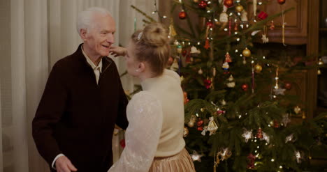 woman giving christmas present to grandfather at home 2