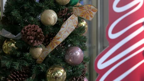 Piñas-Secas-De-Navidad-Y-Adornos-De-Bolas-De-Oro-Se-Ven-Colgando-De-Un-Pino-De-Navidad-Decorado