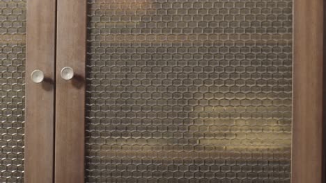 person opening a vintage wooden cabinet door