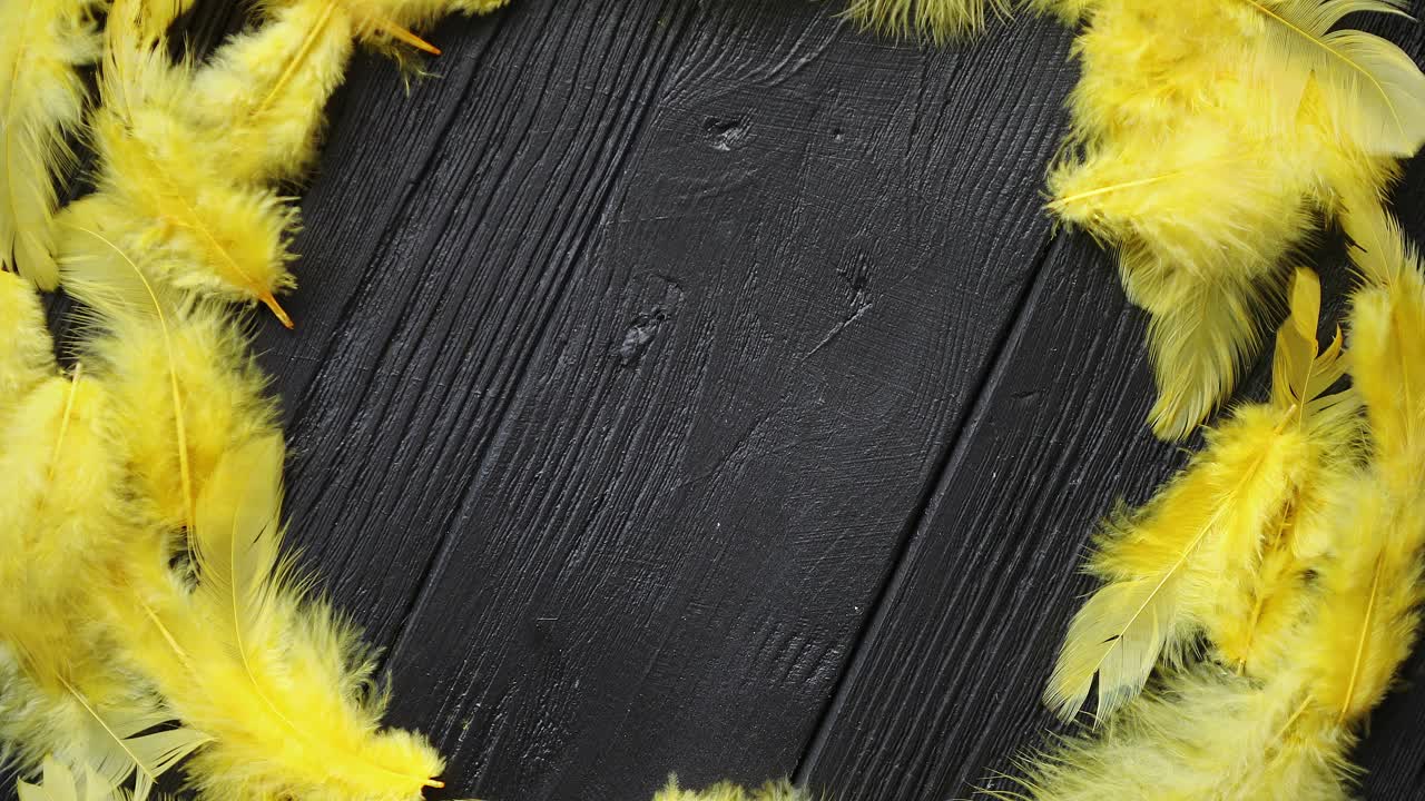 colorida corona decorativa de plumas de pascua sobre fondo de mesa de madera negra