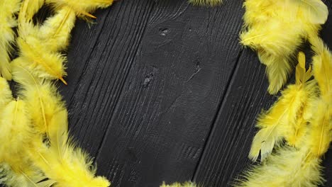 Colorful-decorative-Easter-feather-wreath-on-black-wooden-table-background
