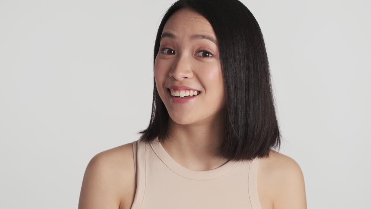 Asian woman smiling on camera.