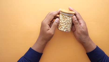 person holding a jar of peanuts