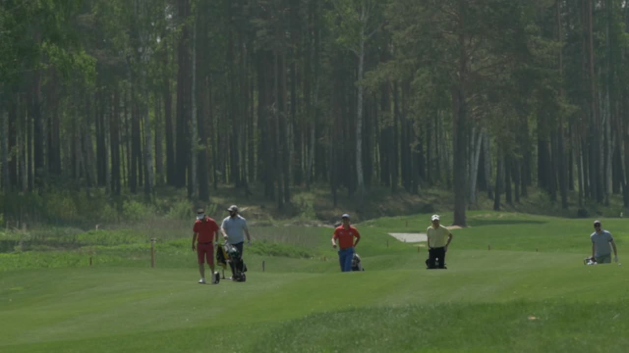 골프 코스에서 걸어가는 골퍼 그룹