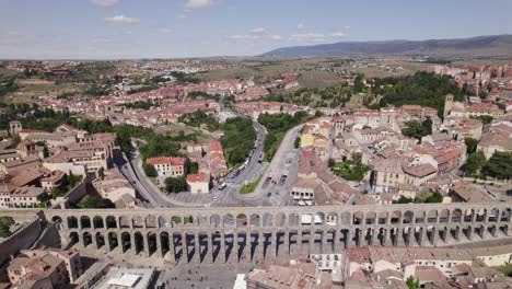 establishing aerial view reversing over the roman aqueduct and scenic old town of segovia skyline