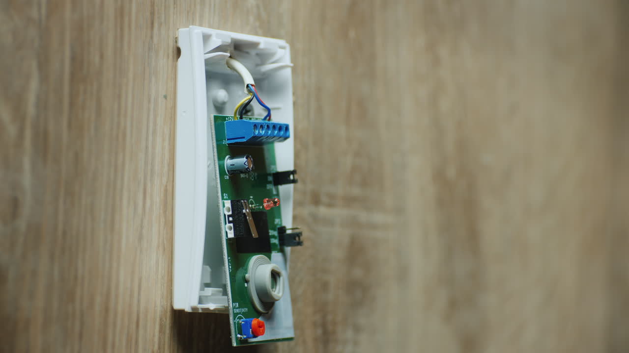 electricista monta sensor de movimiento infrarrojo para sistema de alarma