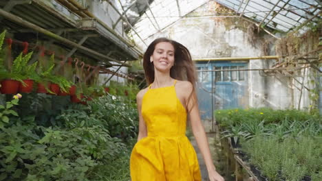 woman in a yellow dress in a greenhouse