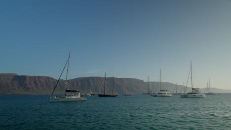 veleros anclados en una bahía de la graciosa, lanzarote durante el mediodía con un cielo despejado