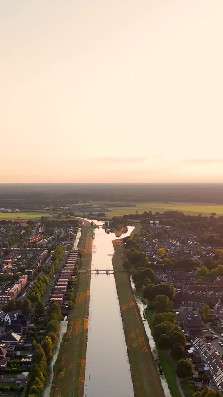 Aerial View of a Canal Winding Through a Residential Area at Sunset
